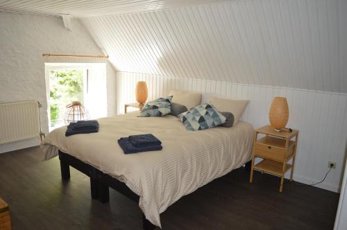 een slaapkamer met een groot bed met kussens erop bij Le Moulin de Chatillon in Saint-Léger