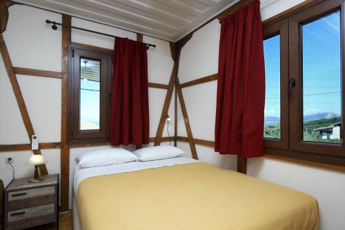 1 dormitorio con 1 cama y 2 ventanas en Stafilos House, en Katouna