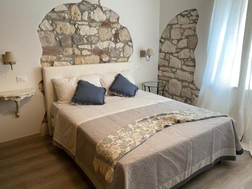 a bedroom with a large bed with a stone wall at UNIQUE ROOMS in Verona