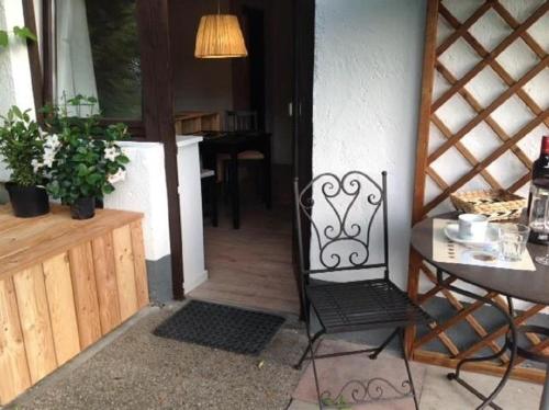 an open door of a house with a chair and a table at Oberholzer Landhaus & Appartement in Ellmau