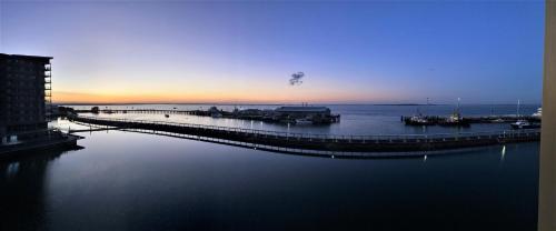 a dock in the water with boats on it at Absolute Waterfront - Tropical Aurora Top Floor Over The Water in Darwin