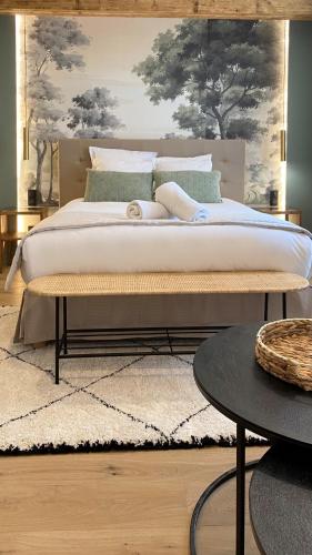 a bedroom with a bed and a table and a rug at Les Granges d'Haillancourt in Ivry-le-Temple