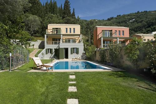 
a person sitting on a bench in front of a house at Erkina Villas Kalami Corfu in Kalami
