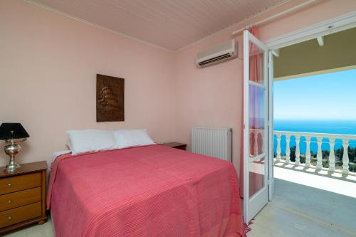 a bedroom with a bed and a balcony with the ocean at Armyra Villas in Volimes