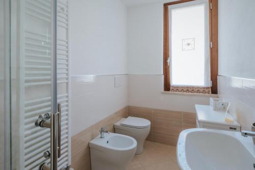 a bathroom with a toilet and a sink and a mirror at I SEE LAKE in Castiglione del Lago