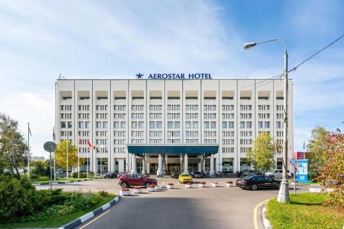 a large white hotel with a sign on top of it at Aerostar Hotel in Moscow