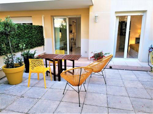 a patio with a wooden table and chairs at Studio neuf 25 m2, terrasse 35 m2 proche port Nice, Centre ville in Nice