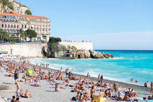 un grupo de personas sentadas en una playa en Studio neuf 25 m2, terrasse 35 m2 proche port Nice, Centre ville en Niza