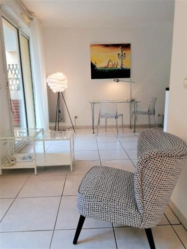 - un salon avec une table en verre et une chaise dans l'établissement Studio neuf 25 m2, terrasse 35 m2 proche port Nice, Centre ville, à Nice