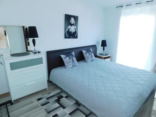 een slaapkamer met een groot bed en een dressoir met een spiegel bij Apartments Ema in Lovran
