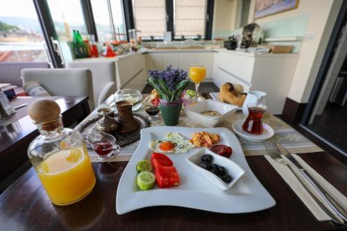 a table with a plate of food and a glass of orange juice at City Boutique Hotel in Sarajevo