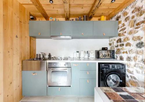 a kitchen with a stove and a washing machine at Chalet Annecy 200m lac, plage & montagnes in Annecy