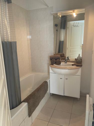 une salle de bain avec une baignoire, un lavabo et un miroir dans l'établissement Les Bastides de Gauguin, à Saint-Laurent-du-Var