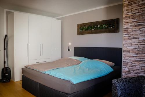 a bed in a bedroom with a brick wall at See-Charme in Uhldingen-Mühlhofen