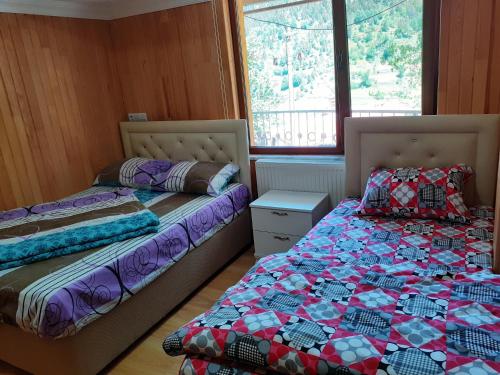 two beds sitting next to each other in a room at GRANOĞLU PANSİYON Uzungöl in Uzungol