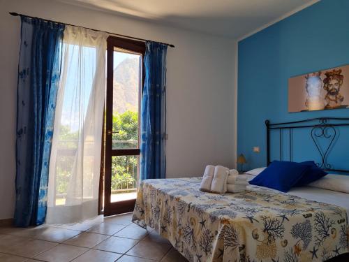 a bedroom with a bed and a large window at Blue Lovely House in San Vito lo Capo