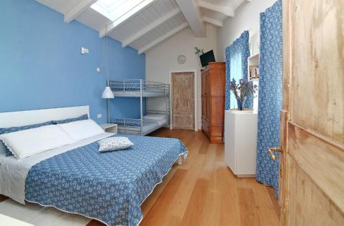 1 dormitorio azul con 1 cama y suelo de madera en Tramontodivino b&b, en San Pietro in Vincoli