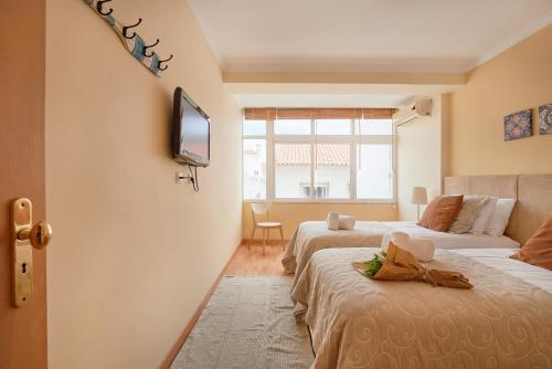 um quarto com duas camas e uma televisão na parede em Apartament near the beach! Cascais! em Cascais