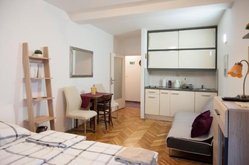 a room with a bed and a kitchen with a table at Studio Apartment Vijenac in Osijek