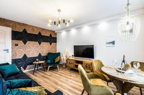 salon ze stołem i telewizorem w obiekcie Apartament Diamentowy Odkryj Zakopane w Zakopanem