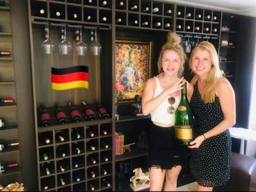 two women standing in a wine cellar holding a bottle of wine at Santa Sophia Del Mar B&B hotel in Santa Marta