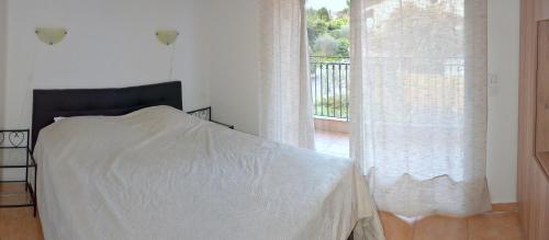 um quarto com uma cama e uma grande janela em L'Orangeraie du Cap em Antibes