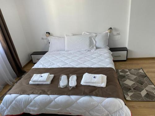 a bedroom with a bed with towels and shoes on it at Casa Cerbului in Vişeu de Sus