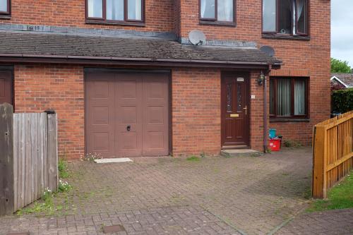 a brick house with two brown garage doors at 15 Bronant in Talgarth