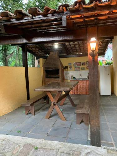 einen Picknicktisch unter einem Holzdach mit Licht in der Unterkunft Chalés Bambá in Ilhabela