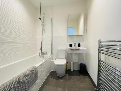 a white bathroom with a toilet and a sink at Southernhay Court Apartments by Staytor Accommodation in Exeter