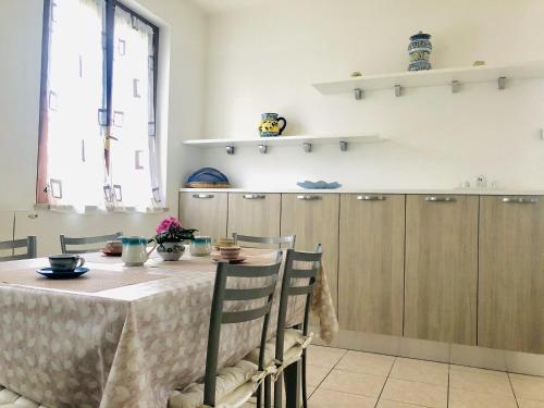 a kitchen with a table with chairs and cabinets at Domus Thalia in Sperlonga
