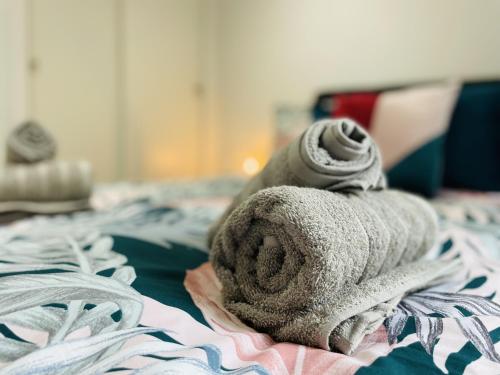 a pile of towels sitting on top of a bed at Southernhay Court Apartments by Staytor Accommodation in Exeter