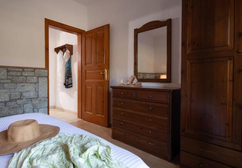 a bedroom with a bed and a dresser with a mirror at Villa Tsitreli in Sikia