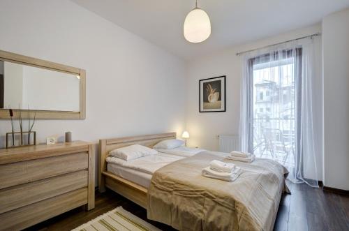 a bedroom with a bed and a large window at Dom & House - Apartamenty Aquarius in Sopot