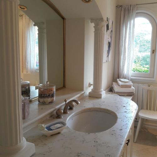 une salle de bain avec un lavabo et un miroir dans l'établissement La Grimaudière, à Auribeau-sur-Siagne