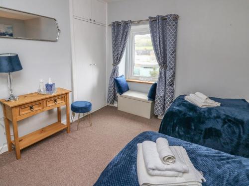 a small room with two beds and a window at Rorkes Cottage in Brecon