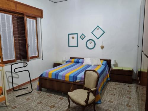 ein Schlafzimmer mit einem Bett und einem Stuhl darin in der Unterkunft Casa Pinù in Pachino