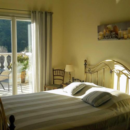 une chambre avec un lit et une porte coulissante en verre dans l'établissement La Grimaudière, à Auribeau-sur-Siagne
