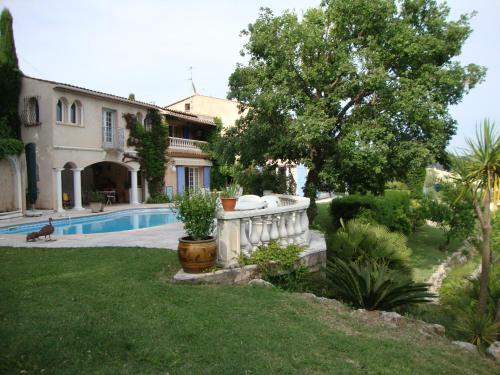 une maison avec une piscine dans une cour dans l'établissement La Grimaudière, à Auribeau-sur-Siagne