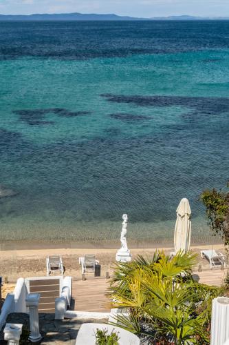 a view of a beach with chairs and the ocean at Bay View Suites in Ayios Nikolaos Sithonia