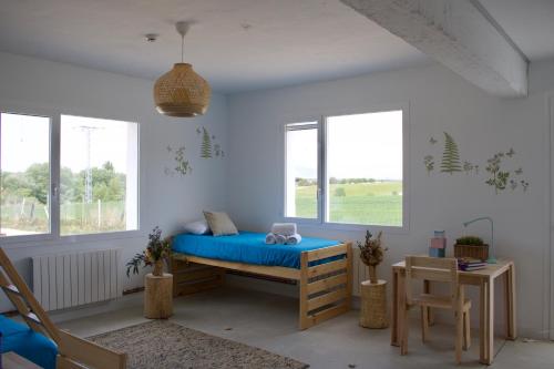 Schlafzimmer mit einem Bett mit blauer Bettwäsche und Fenstern in der Unterkunft Entheos in Lerín