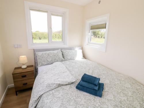 ein Schlafzimmer mit einem Bett und einem blauen Handtuch darauf in der Unterkunft Malvern View Lodge in Worcester