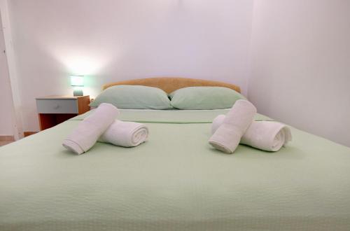 a bed with three pink pillows on it at Rose Apartment in Zadar