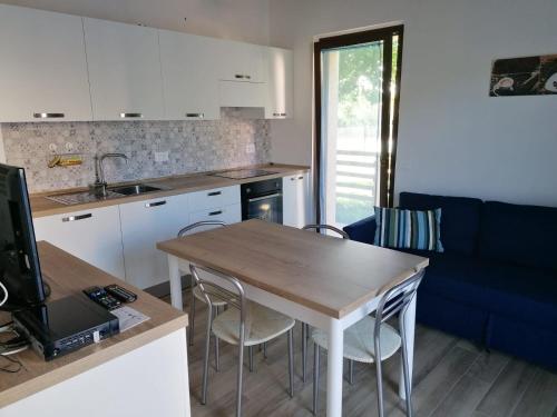 a kitchen and living room with a table and chairs at Il Piccolo Uliveto del Conero in Camerano