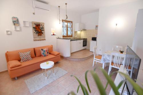 a living room with an orange couch and a table at Rose Apartment in Zadar
