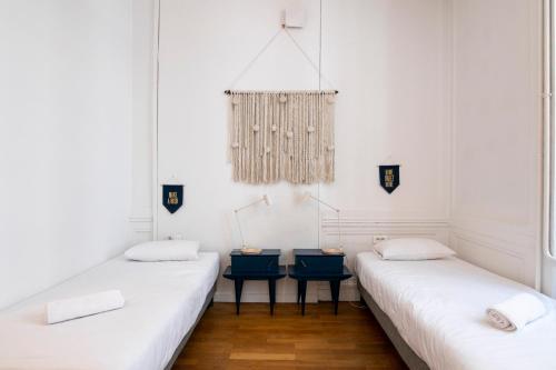 two beds in a room with white walls at SLO Hostel Lyon les Pentes in Lyon