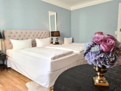 a bedroom with two beds and a bouquet of flowers at Altstadthotel Molitor in Bamberg