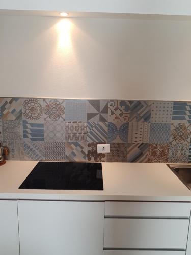 cocina con encimera blanca con azulejos en la pared en CASETTE BRIGANTI - monolocali indipendenti con angolo cottura, en Gallipoli