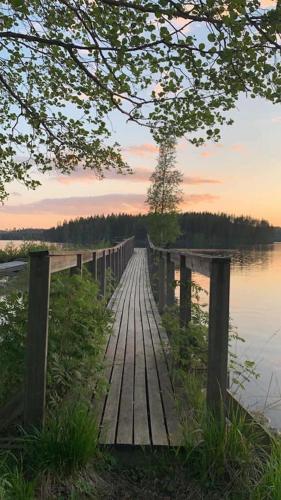 a wooden bridge over a body of water at Rämsbyns Fritidsområde - Den perfekta platsen för avkoppling in Idkerberget