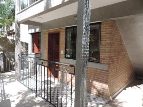 a house with a balcony with a metal fence at Chalés Estrada Real in Conceição da Ibitipoca